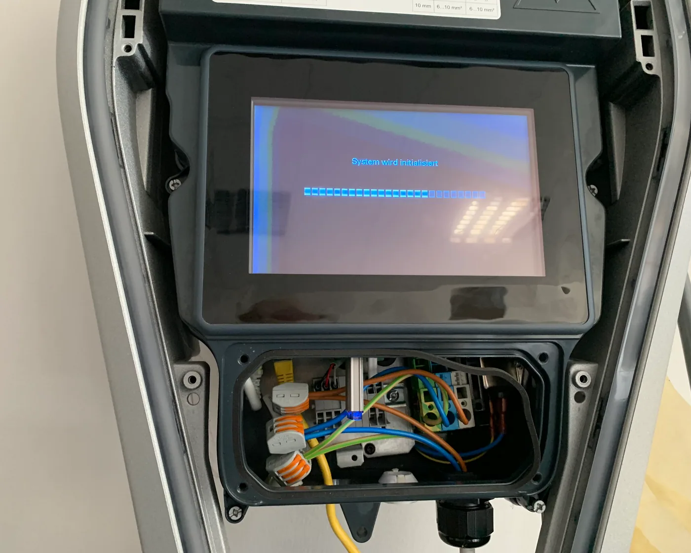 Geöffnete Wallbox mit Display und Verkabelung in einem OCPP-Testaufbau